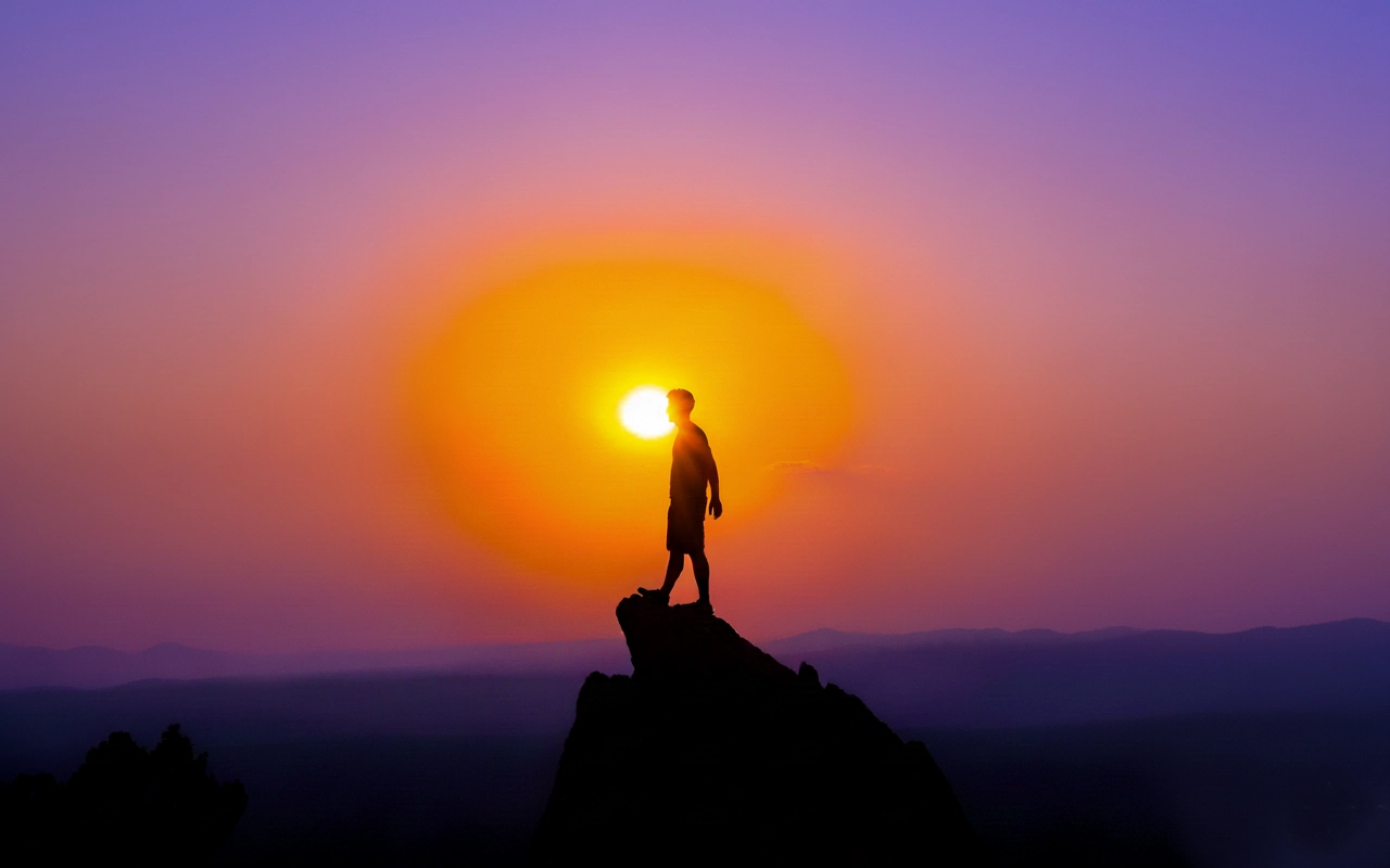 silhouette scrutant le coucher de soleil très coloré